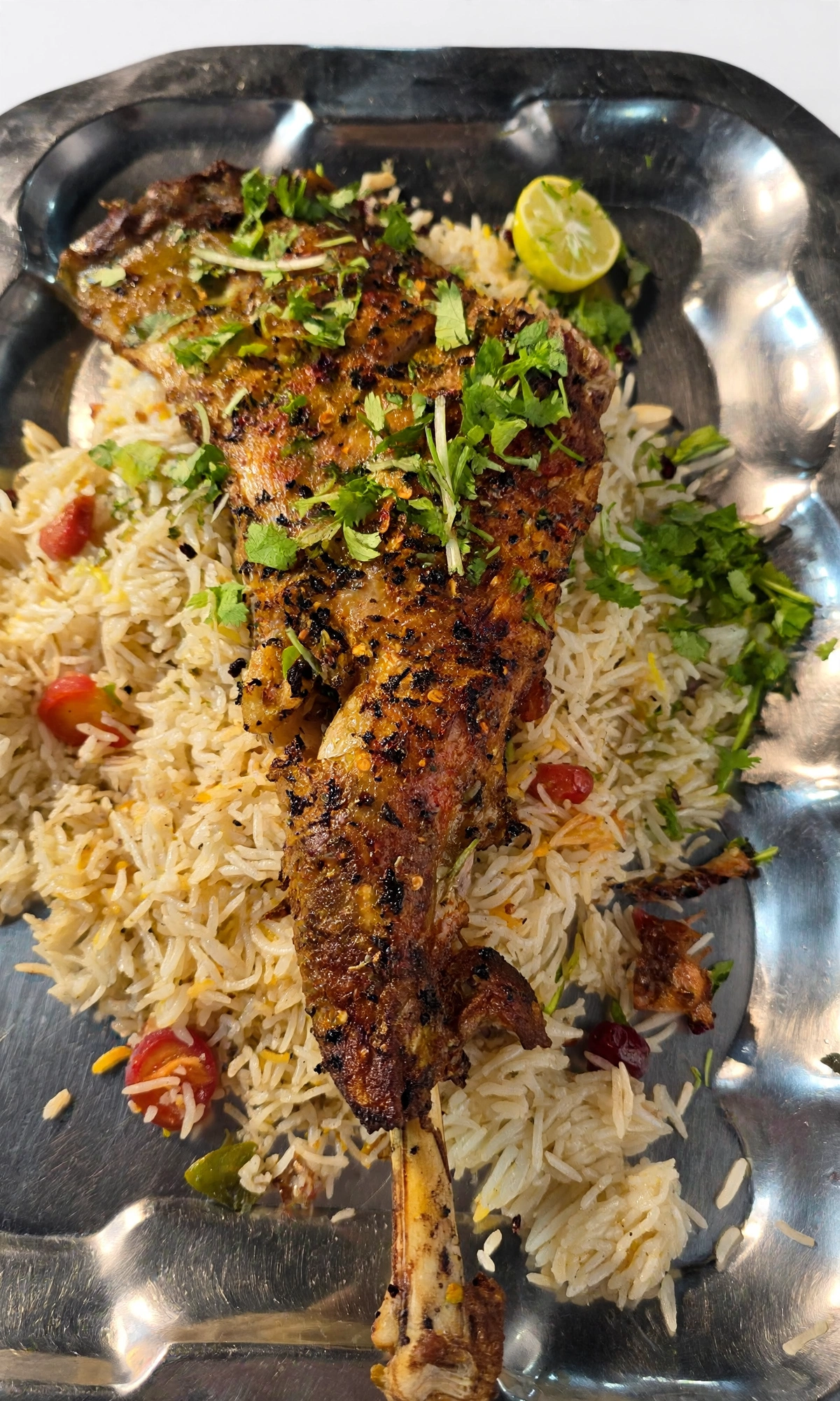 Mutton raan sajji — whole marinated raan slow-roasted Balochi-style on saffron rice